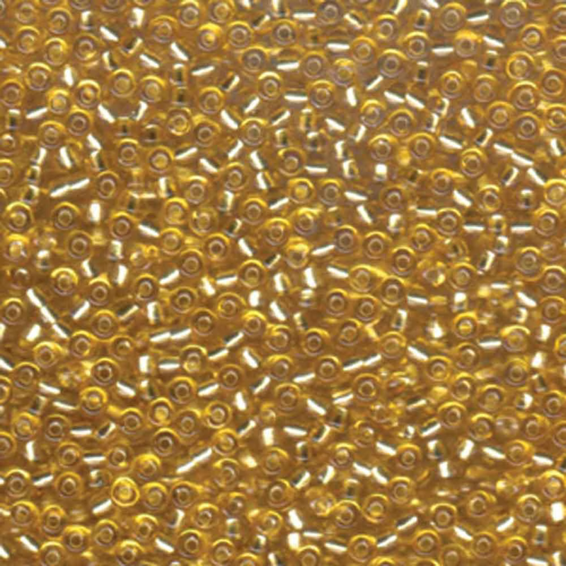 Close-up of gold delica beads with a blurred background