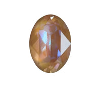 Oval faceted fancy gemstone with brown and purple hues on white background
