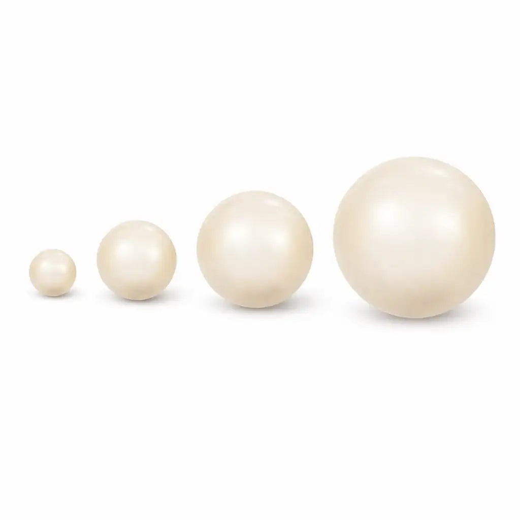 Four cream pearls of different sizes on a white background