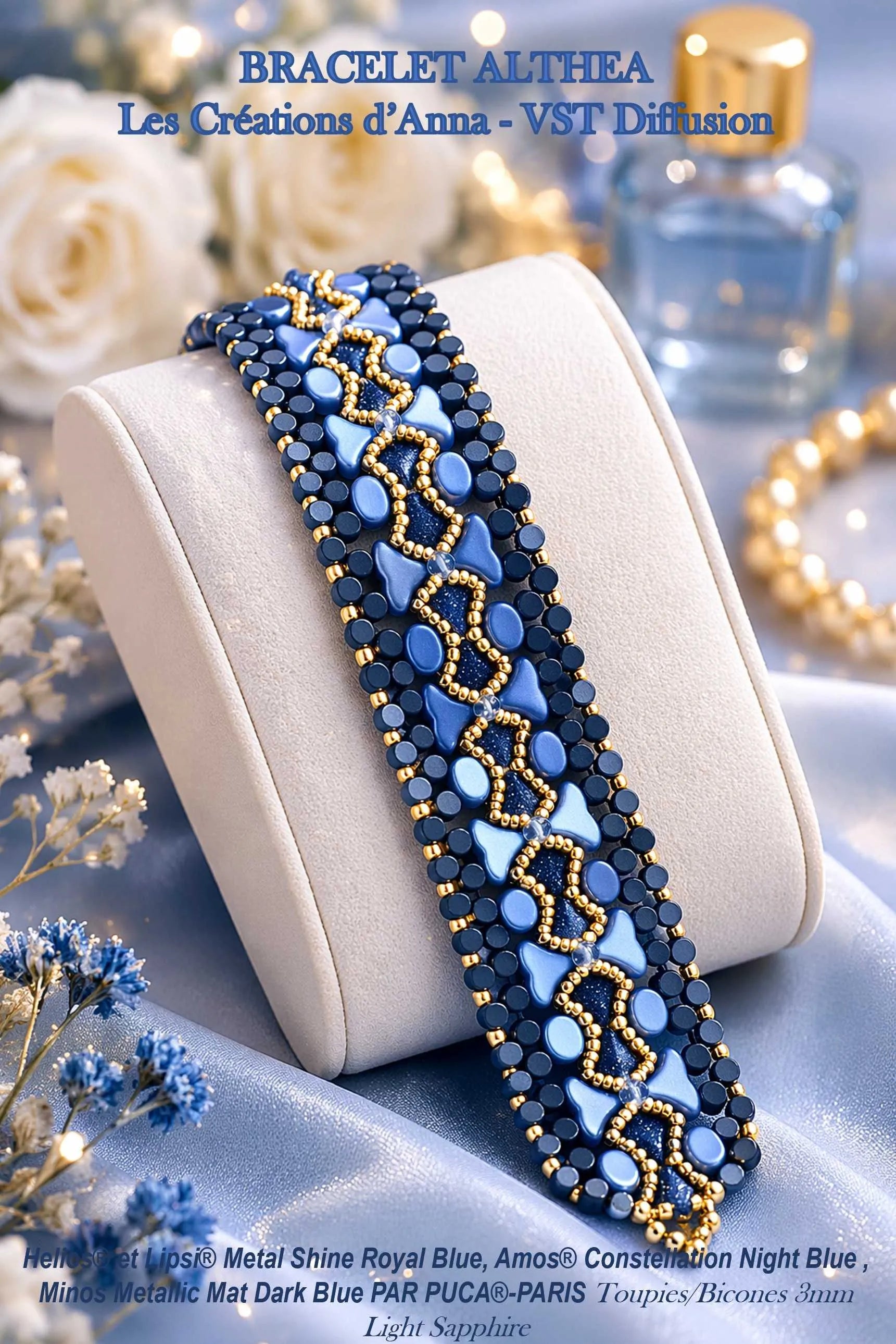 Beaded bracelet with blue and gold pattern on a white cushion, surrounded by flowers and blurred background.