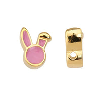 Gold and pink bunny ear charm on a white background