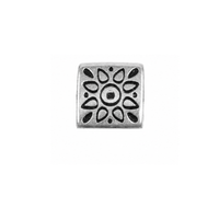 A square silver-toned metal charm featuring a decorative black oxidized floral or sunburst pattern, centered on a plain white background.
