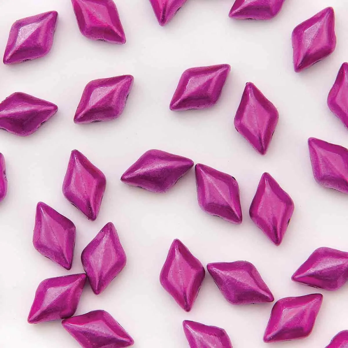 Pattern of hot pink diamond-shaped 2-hole glass beads on a white background