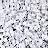 Close-up of transparent rectangular plastic beads with two holes on black background