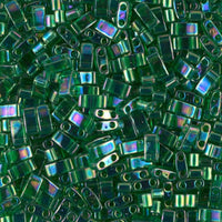 Close-up of iridescent green rectangular glass beads with two holes for jewelry making