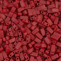 Close-up of numerous small red plastic bead spacers with two holes each