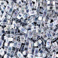 Close-up of transparent, rectangular seed beads with two holes on a black background