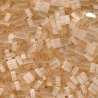 Close-up of translucent plastic pellets on a brown textured surface