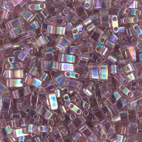 Close-up of iridescent purple rectangular glass beads with two holes for jewelry making
