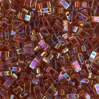 Close-up of iridescent amber rectangular glass beads with two holes for jewelry making