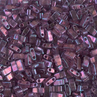 Close-up of shiny purple rectangular glass beads with two holes for jewelry making
