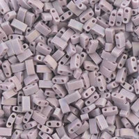 Pile of small, matte lavender two-hole rectangular beads for jewelry making