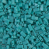 Close-up of turquoise rectangular beads with two holes, used for jewelry making