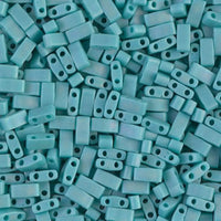 Close-up of matte turquoise blue two-hole rectangular beads for jewelry making
