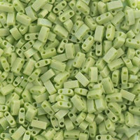 Close-up of small matte light green rectangular two-hole beads packed tightly
