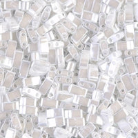 Close-up of translucent white and beige rectangular beads with two holes, densely packed