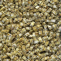 Close-up of cream and yellow rectangular ceramic beads with two holes, textured surface