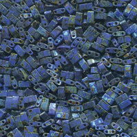 Close-up of small blue rectangular beads with two holes and rustic speckled patterns