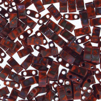 Close-up of reddish-brown rectangular beads with two holes, translucent and glossy