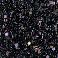 Close-up of small black rectangular beads with two holes and iridescent sheen
