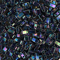 Close-up of shiny iridescent black rectangular glass beads with two holes, craft supplies