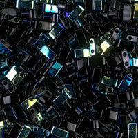 Close-up of small shiny black two-hole rectangular beads with reflective surfaces