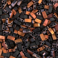 Close-up of black and brown two-hole rectangular beads scattered together