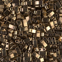 Close-up of numerous small shiny metallic rectangular beads with two holes, used for jewelry making