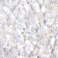 Close-up of white iridescent rectangular beads with two holes, ideal for jewelry making