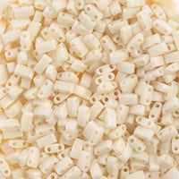 Pile of matte cream ivory cylindrical two-hole beads for jewelry making and crafts