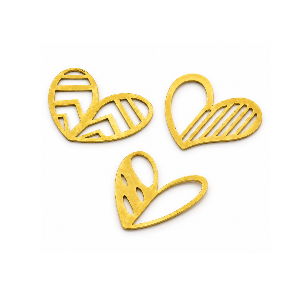 Three gold-colored metal heart-shaped cutouts with different internal line patterns, arranged on a plain white background.