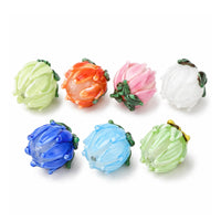 Handmade lampwork tulip flower beads in seven assorted colors on white background