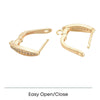 Gold-tone hoop earrings with embedded small crystals and easy open/close clasp design on white background