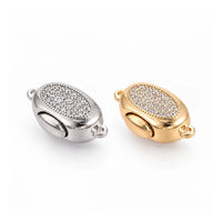 Gold and platinum Luna bayonet peanut clasps with clear cubic zirconia on a white background