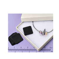 Shine-Rite anti-tarnish tab placed inside a jewelry box with jewelry for tarnish protection.