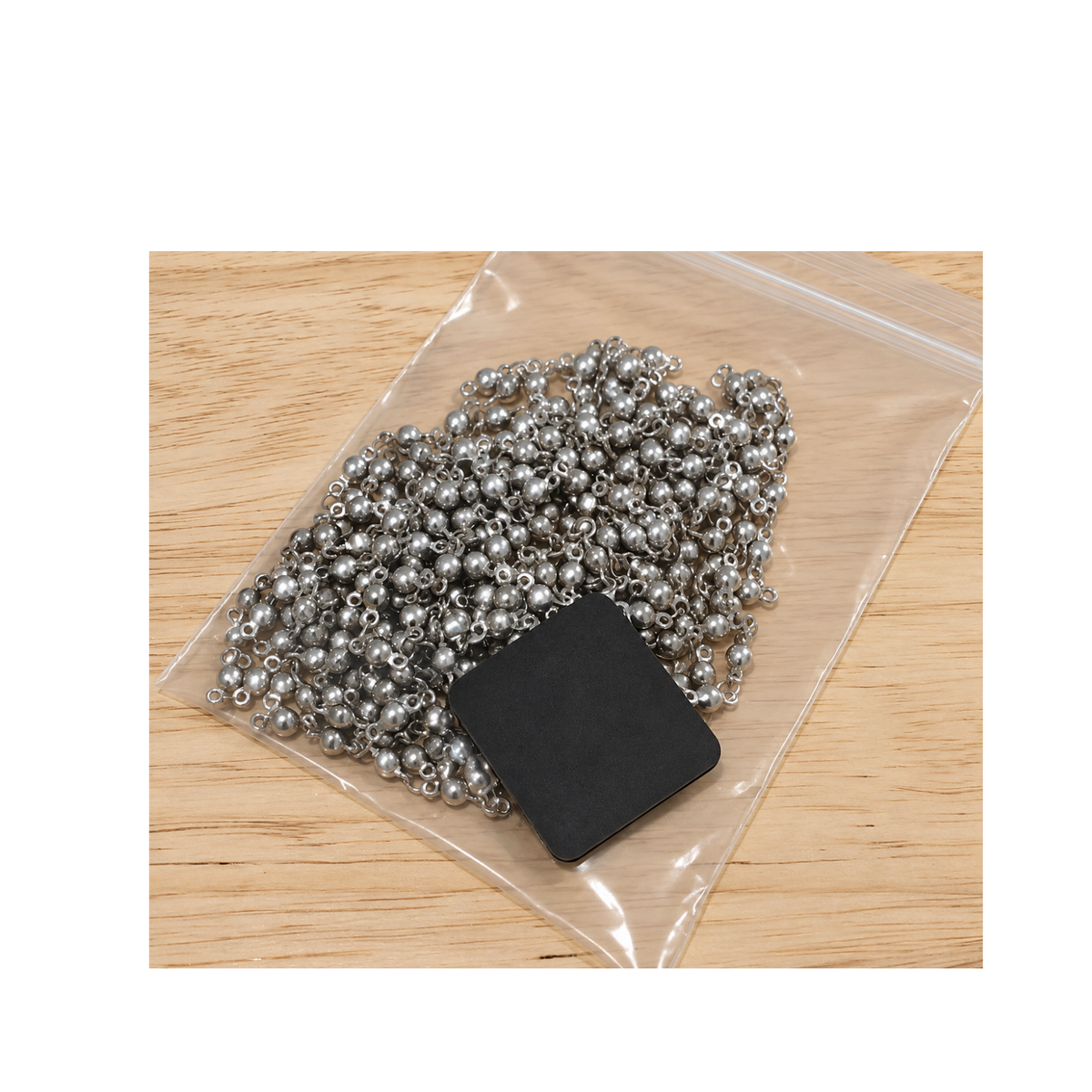 Shine-Rite anti-tarnish tab stored with metal jewelry findings in a resealable bag.