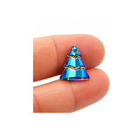 Small blue Swarovski crystal Christmas tree charm held between fingertips to show its petite 15 × 13 mm size