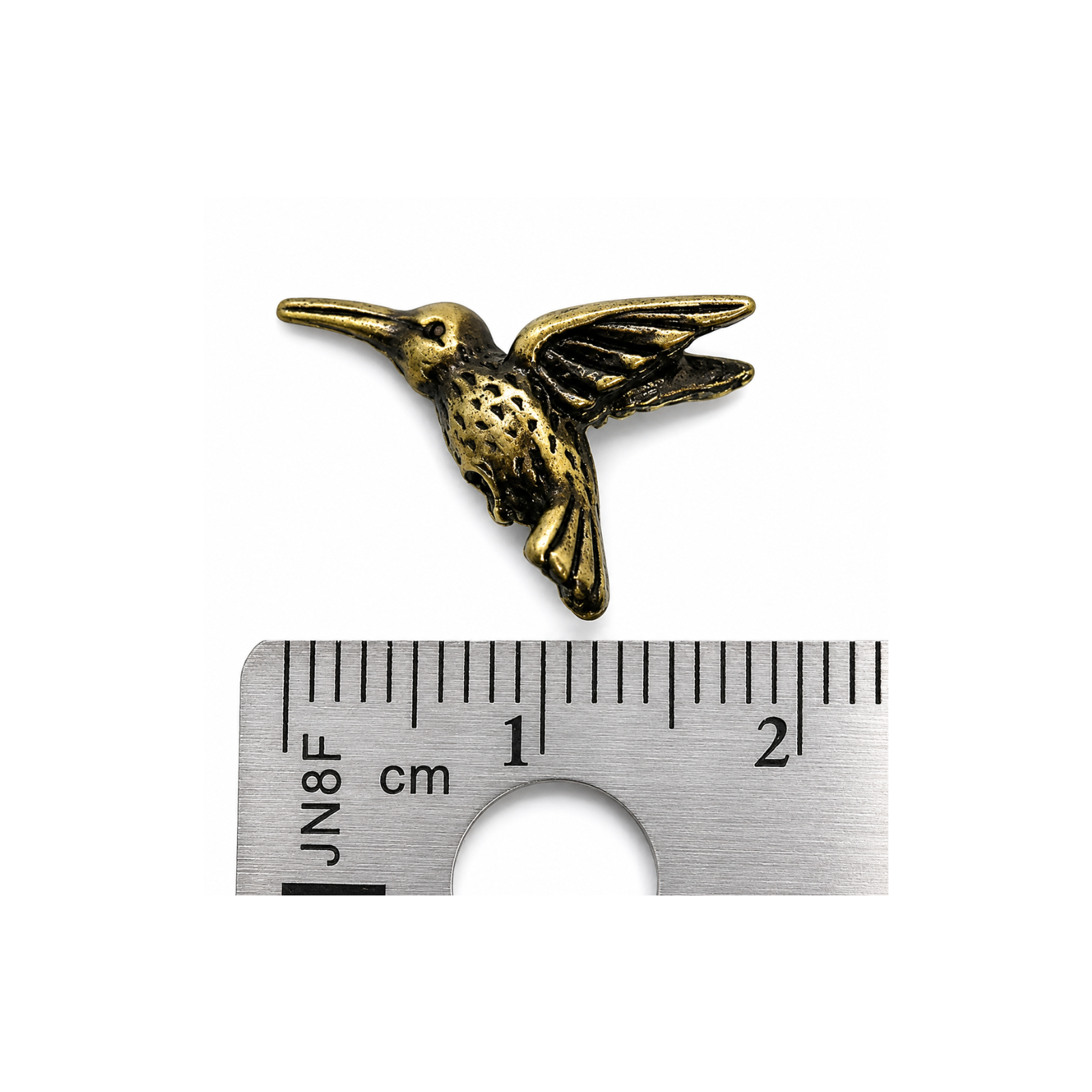 TierraCast hummingbird bead shown beside a metric ruler for size reference, approximately 20mm wide.