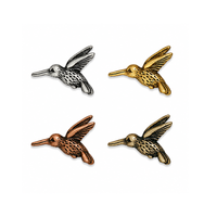 TierraCast hummingbird beads in four metal finishes, shown on a white background.