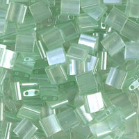 Close-up of green glass 2-hole beads called tila beads