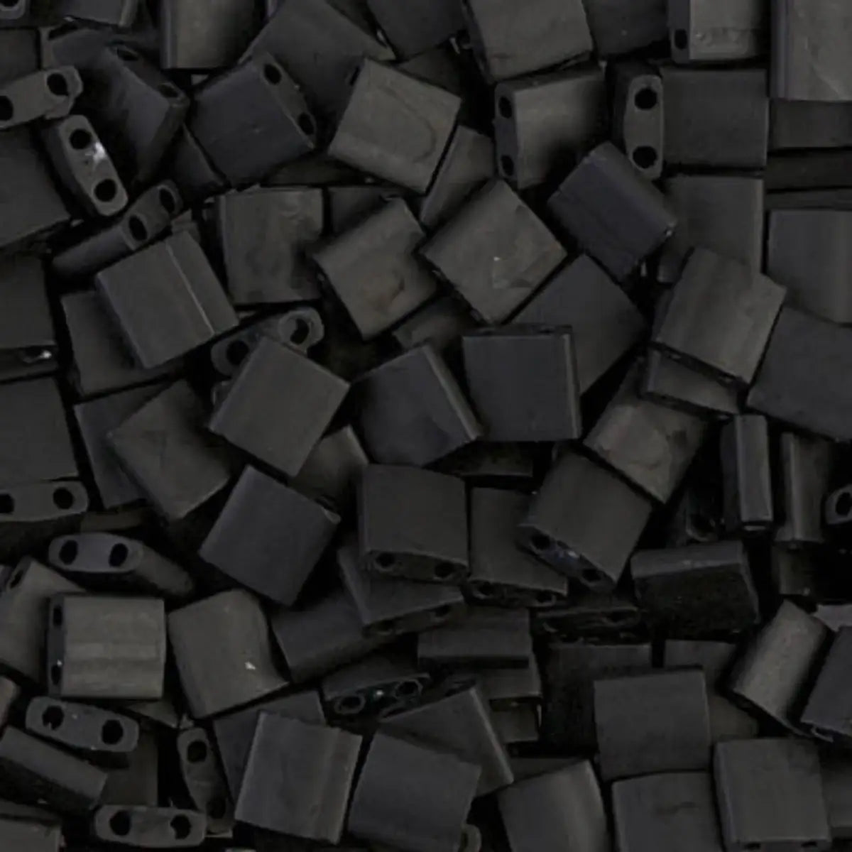 Close-up of a pile of black glass 2-hole beads