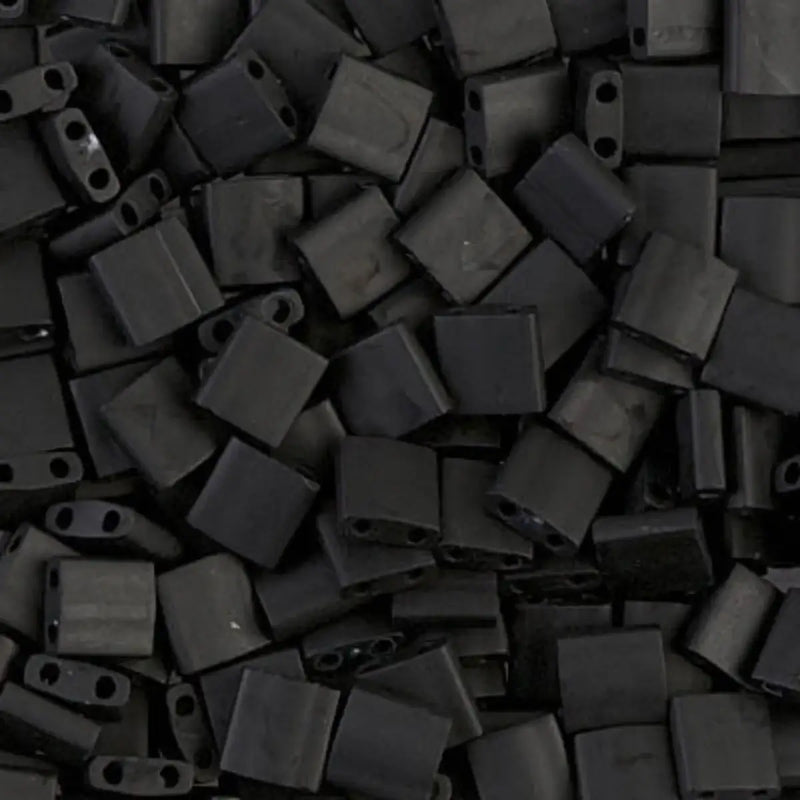 Close-up of a pile of black glass 2-hole beads