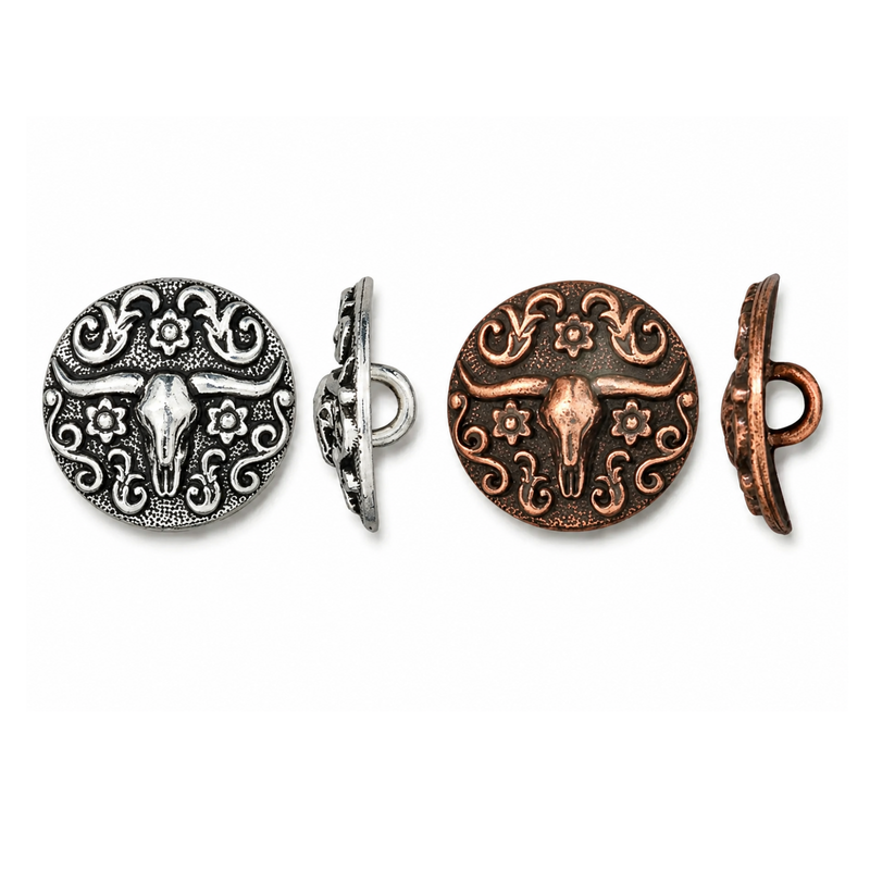 Two round decorative metal button-like charms with an engraved longhorn skull and floral scroll pattern, shown front and back in silver and copper tones on a white background.