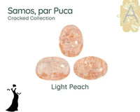 Three light peach-colored 2-hole stones with 'Samos, par Puca' text and 'Cracked Collection' label on a white background.